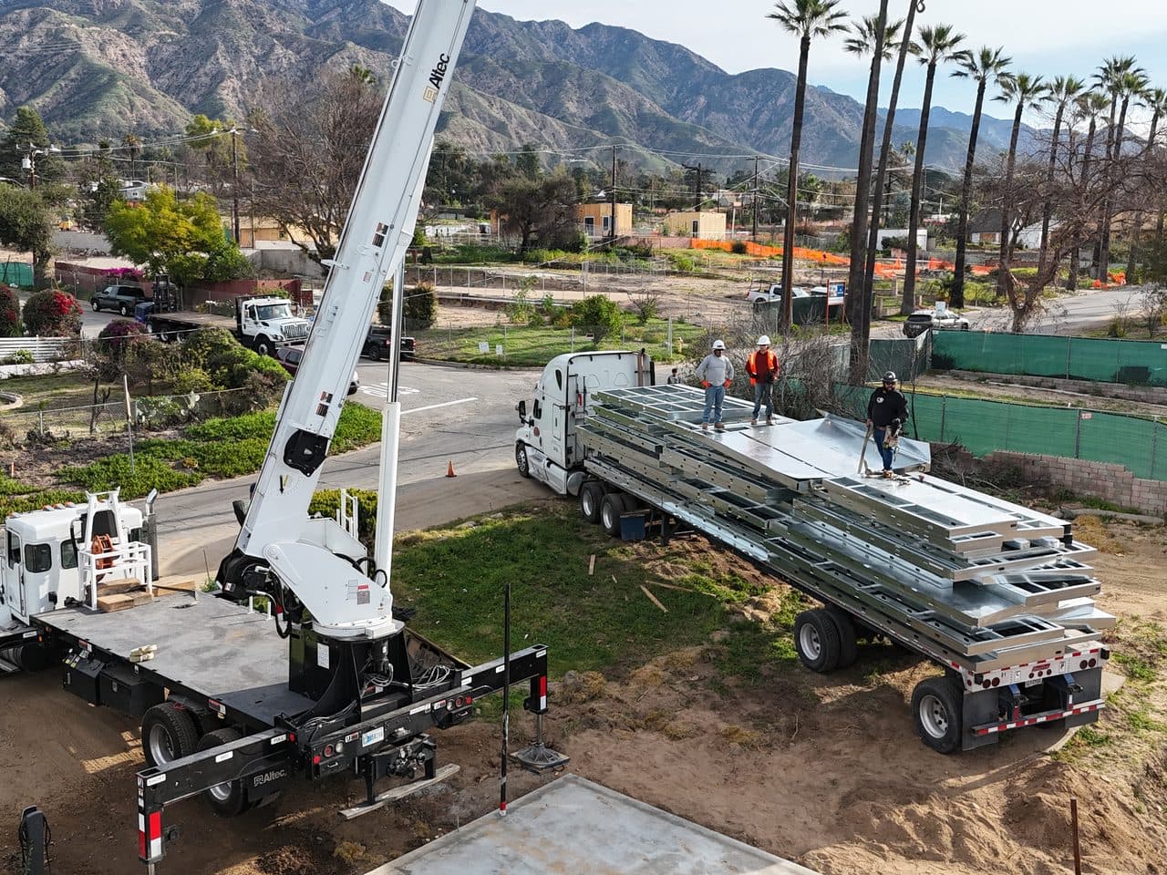 Light-gauge steel wall panels delivered by flatbed and crane to a job site