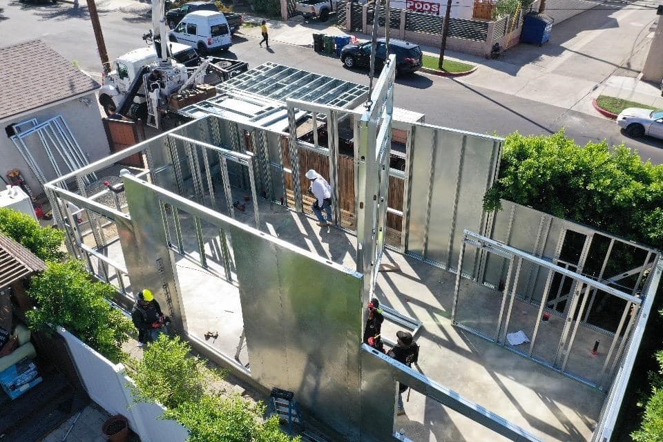 ADU Concepts crew erecting a panelized light-gauge steel ADU frame on a Los Angeles County backyard lot